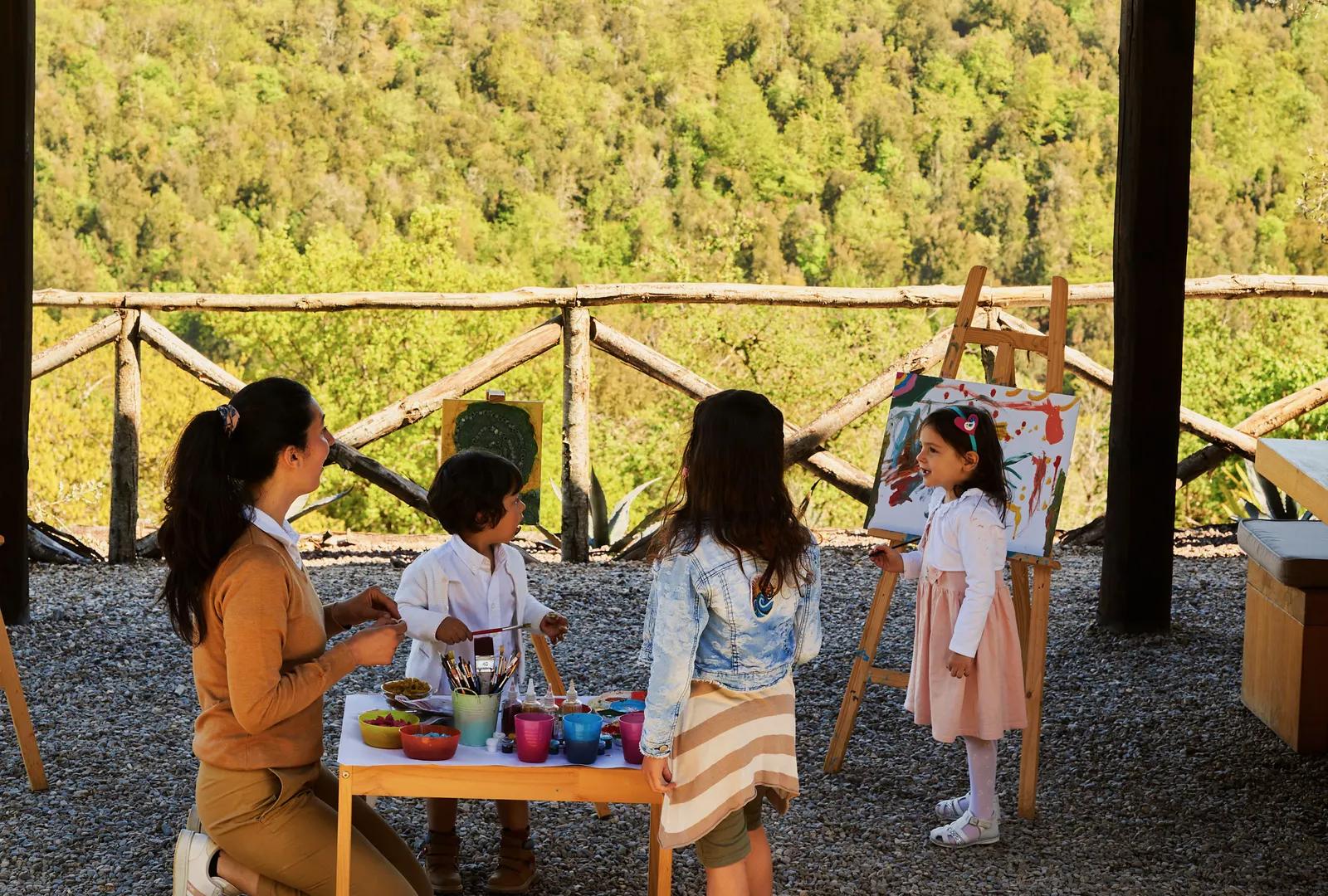 Kids painting in a large garden with panoramic views.