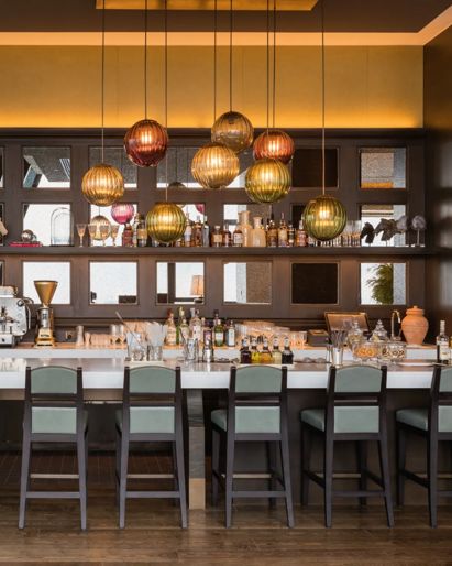 Phnom Penh hotel bar with a  white marble counter and  gray stools. 