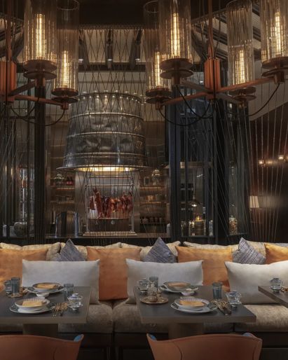 Phnom Penh hotel restaurant  with long banquette seating  and orange cushions. 
