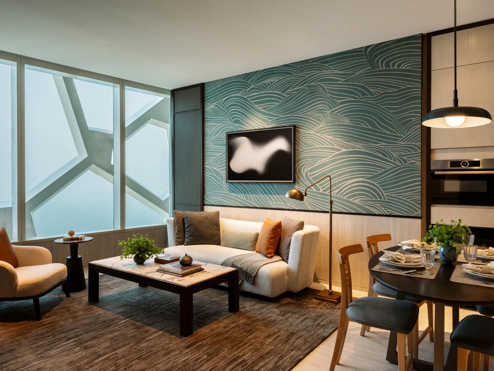 A modern living room features a curved sofa and a round table with a vase of flowers.