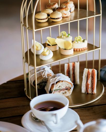 Three-tier gold stand with afternoon tea service.