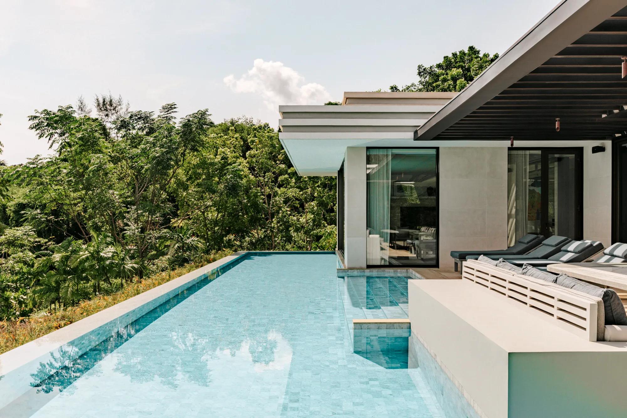 Partial ocean view Thai pool villa with private pool and tropical surroundings at sunset.