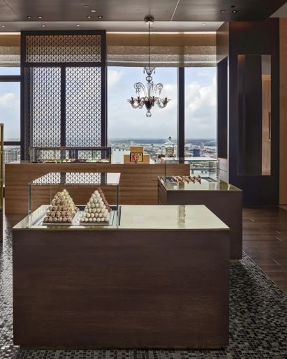 Hotel pastry shop with display  cases and chandelier. 