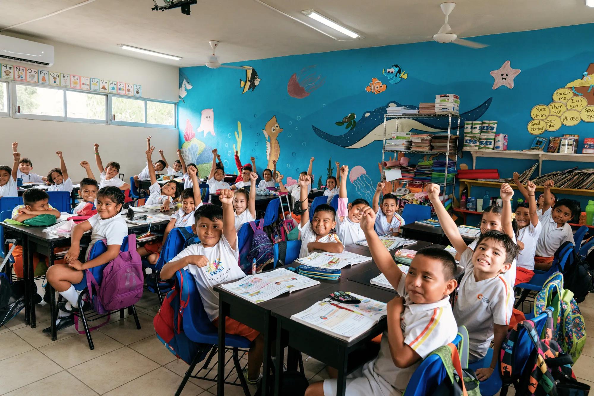 Kiin Beh students cheering together, celebrating in a vibrant and happy moment.