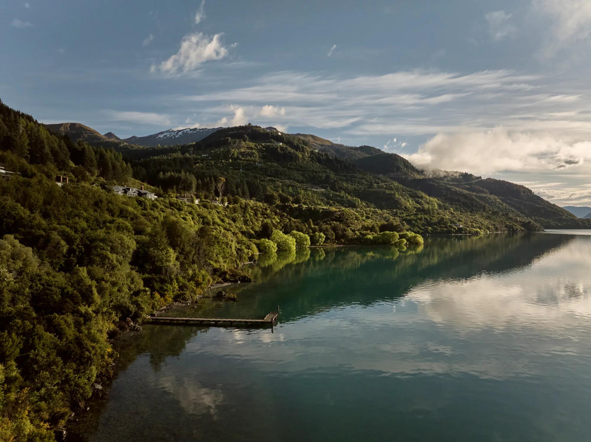 Aerial view of Rosewood Matakauri looking back from the lake tucked into native forest.