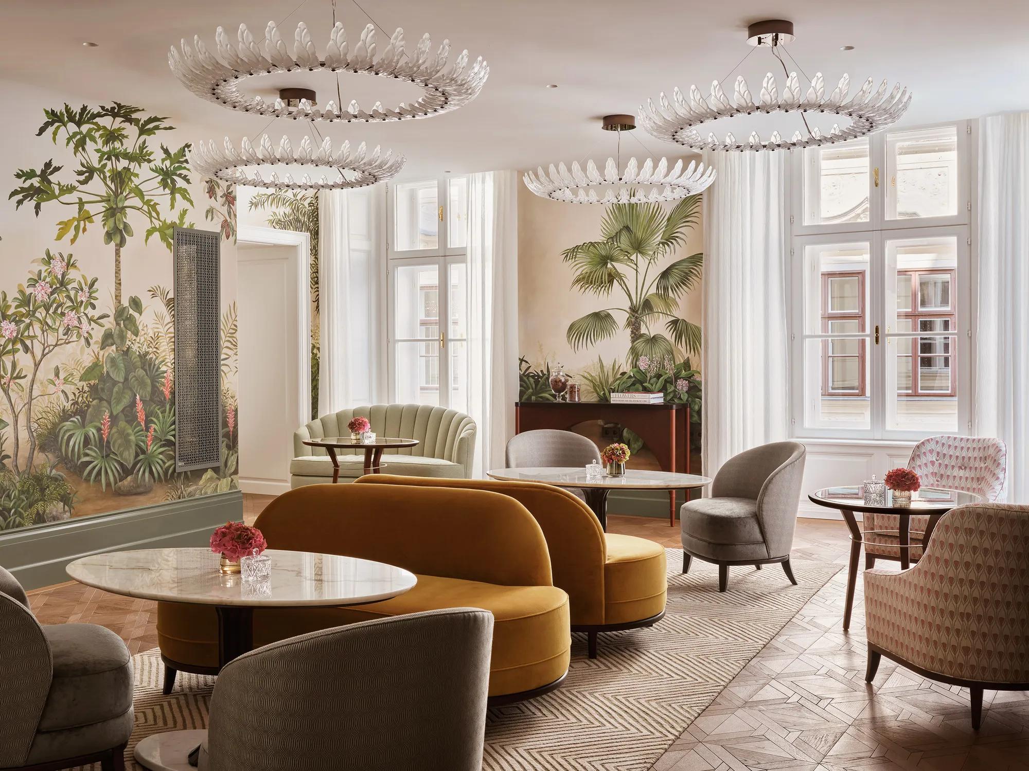 Salon Aurélie at Rosewood Vienna, an elegant lounge with hand-painted botanical murals, velvet seating, and natural light creating a refined, tranquil atmosphere.