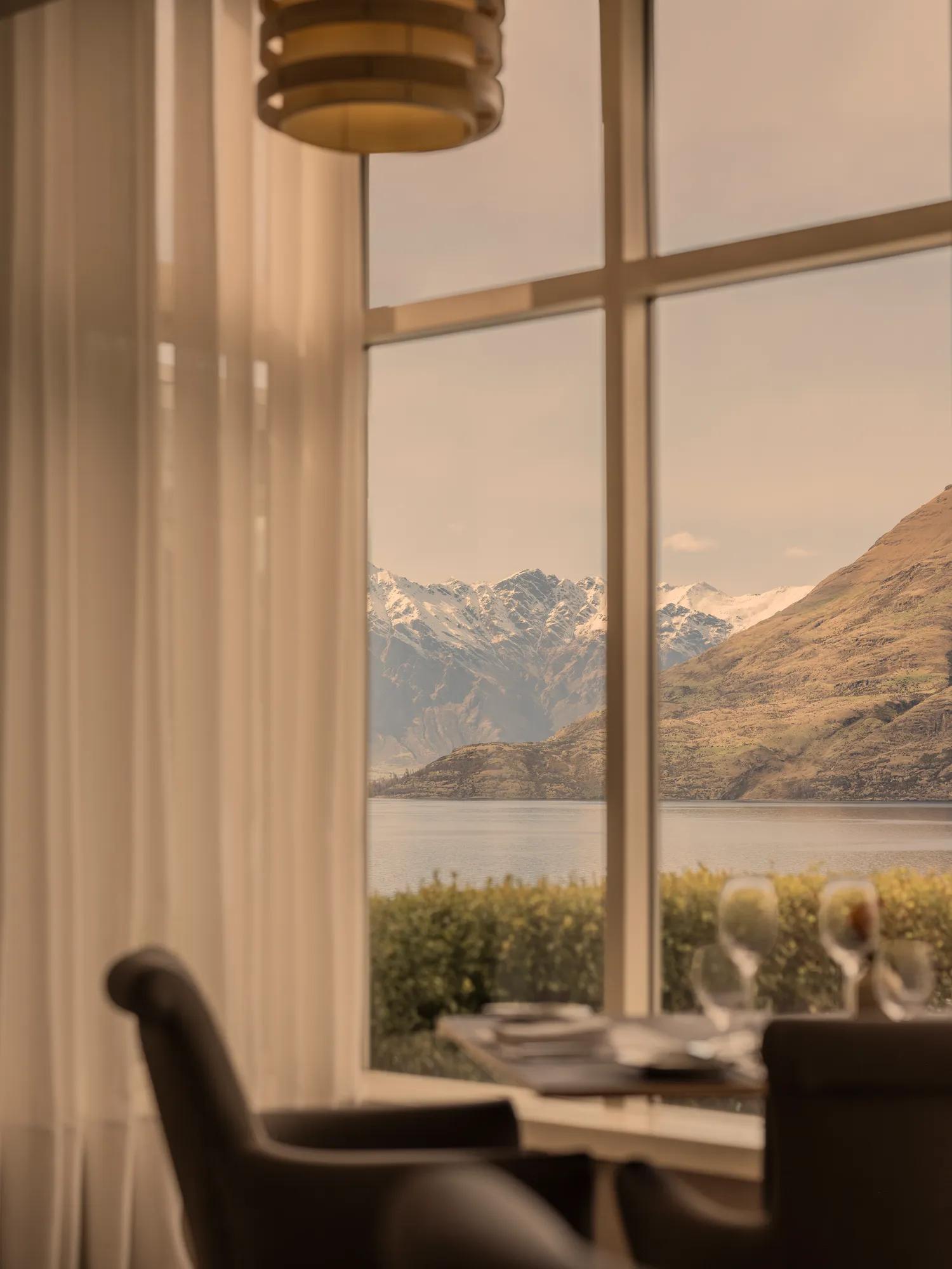 Romantic table for two in a fine dining restaurant with panoramic lake and mountain views through a large picture window