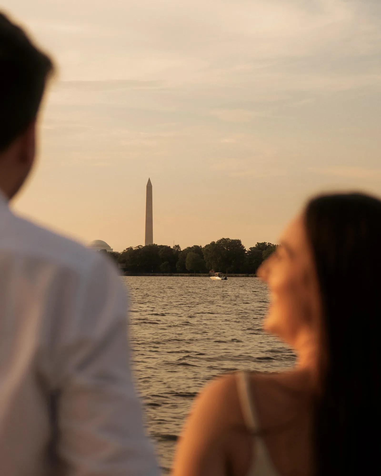 A blurred couple on a boat on the Potomac River glancing at the Washington Monument