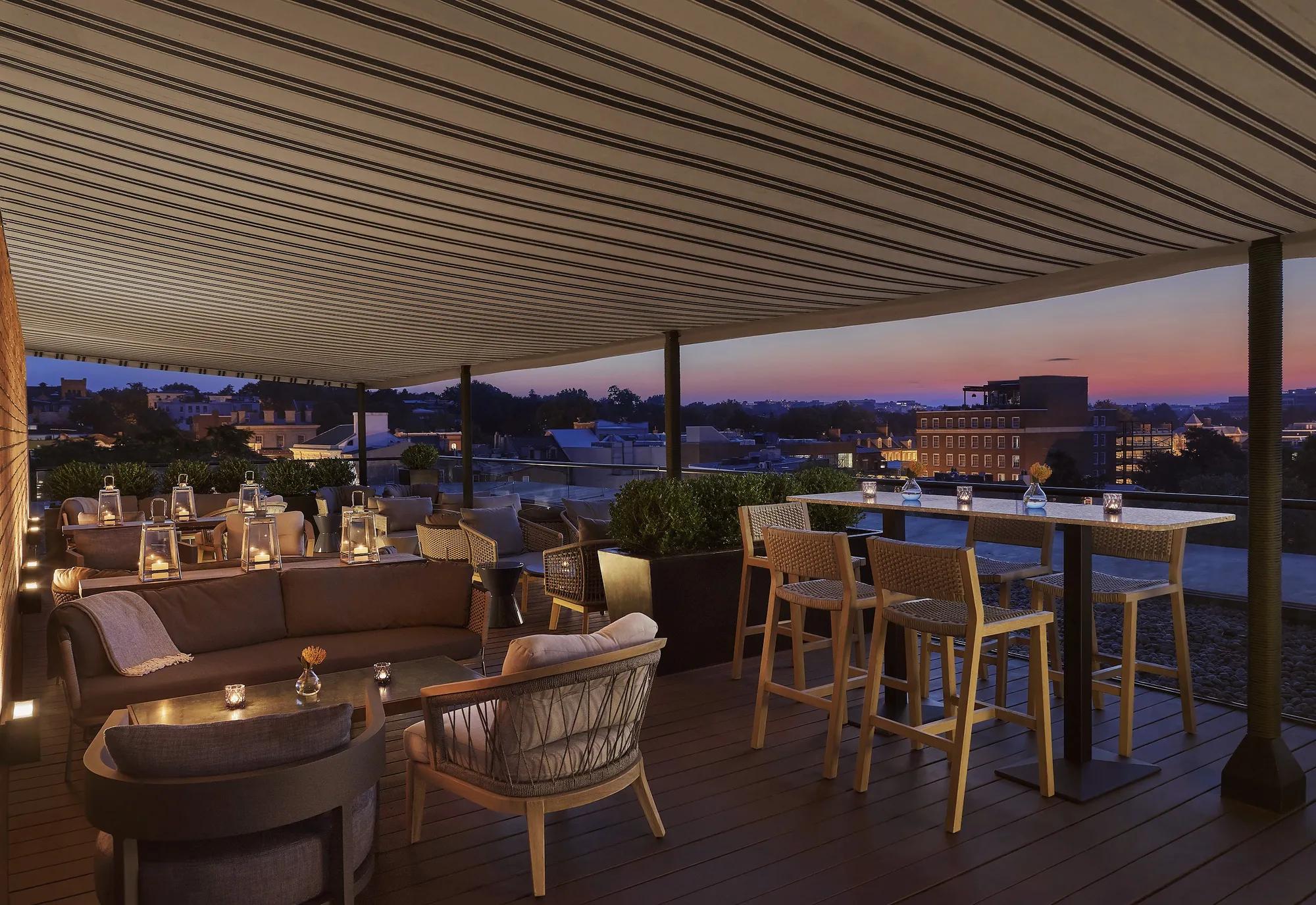 Rooftop with 360-degree views in the heart of Georgetown with modern furniture and a sunset in the background