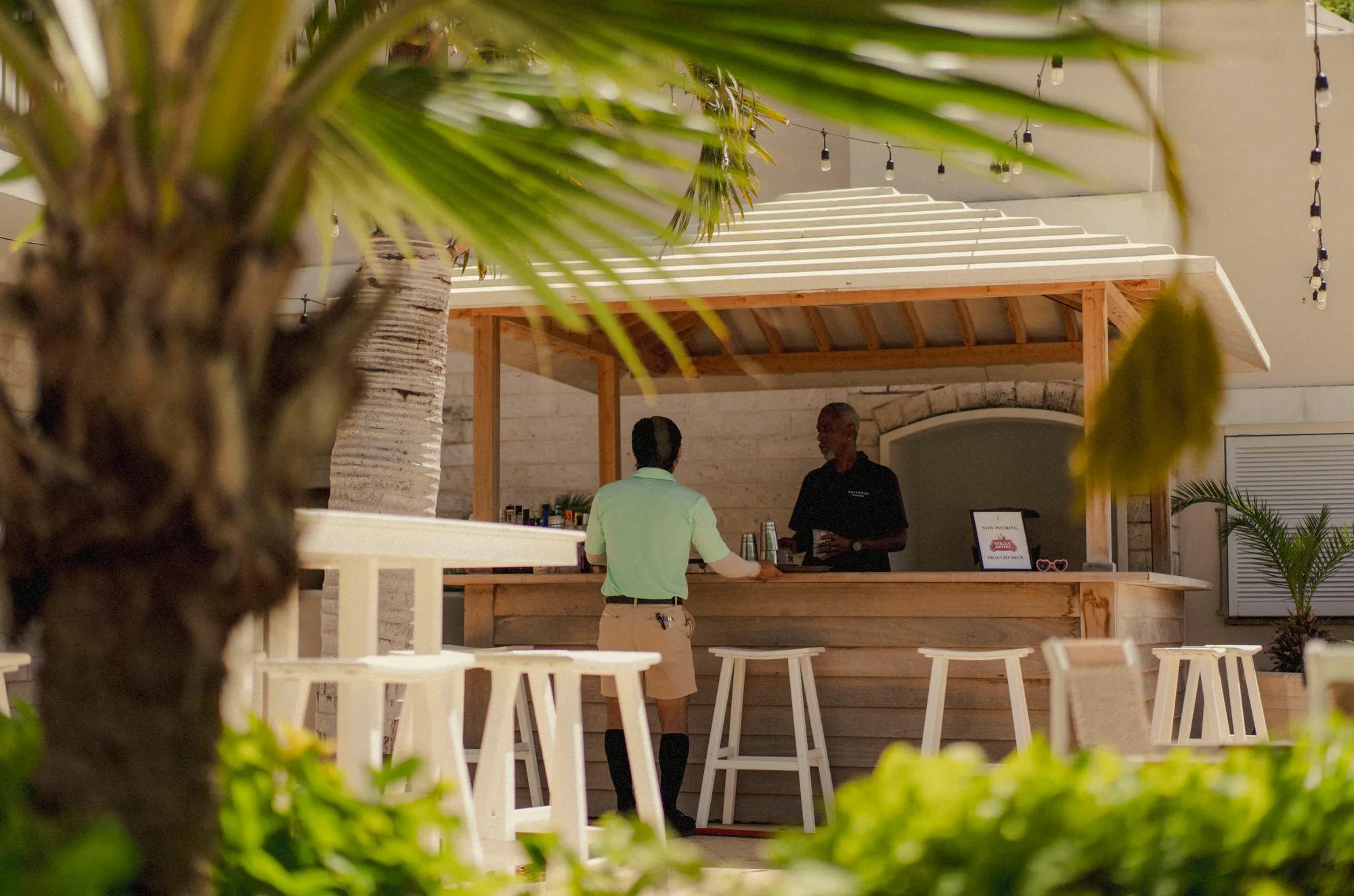 Server grabbing drinks from the poolside bar