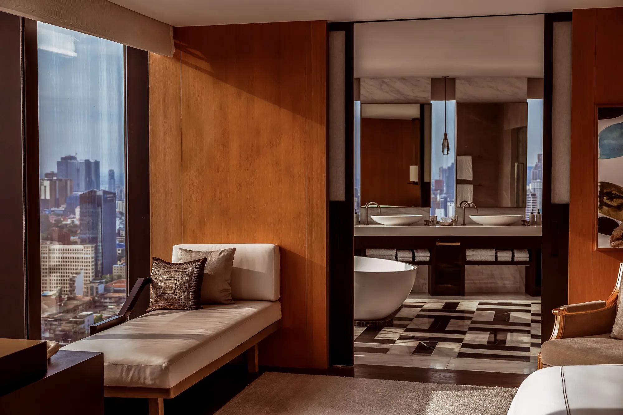 Phnom Penh hotel suite with  window seat overlooking city  skyline. 