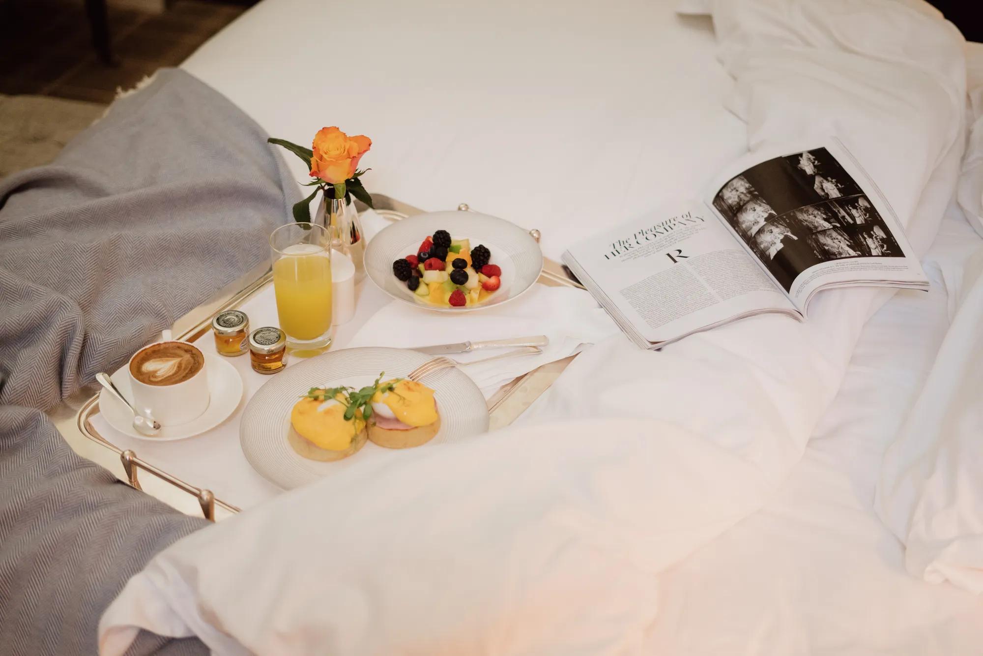 A man in a suit is pouring red wine from a  bottle into a glass.