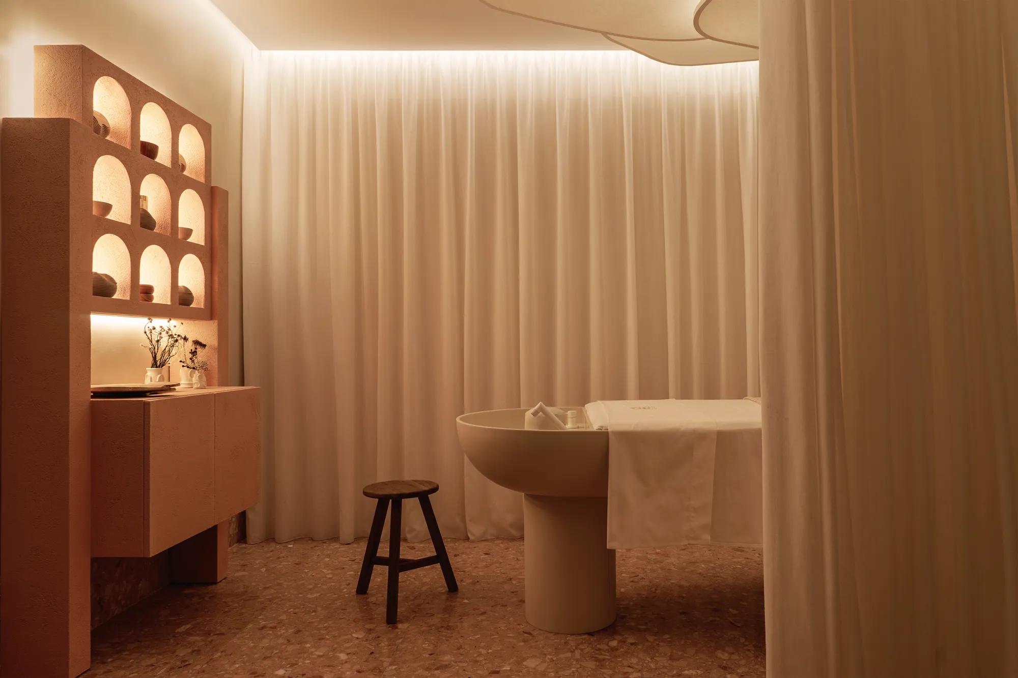 Spa cabin with white walls and a wooden shelving unit, offering a serene and minimalist atmosphere