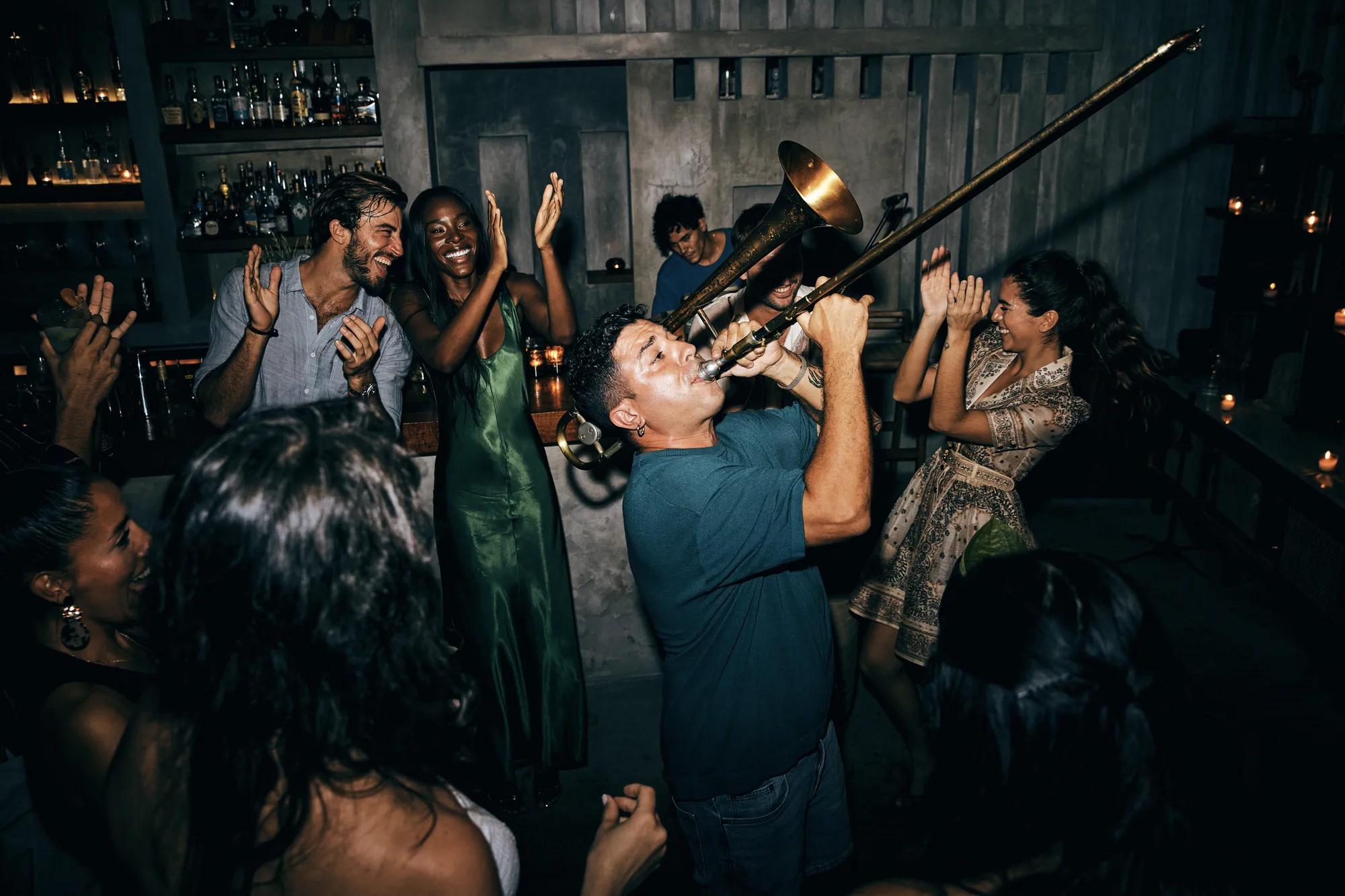 - Beachfront nighttime dinner setup with palm trees, softly lit palapas, and an oceanfront ambiance.