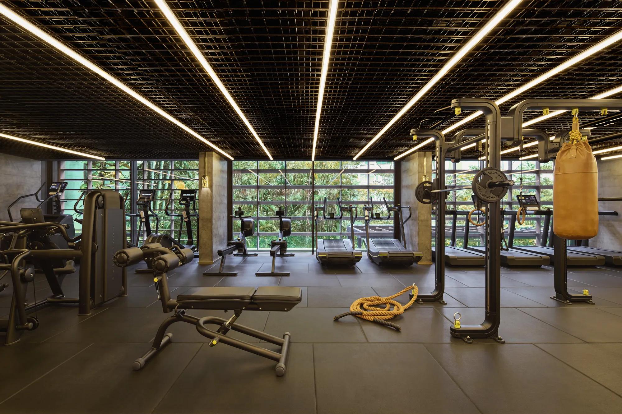 A photo of the Fitness Center at Rosewood São Paulo, showcasing equipment such as treadmills, barbells, weights, a punching bag, and more.