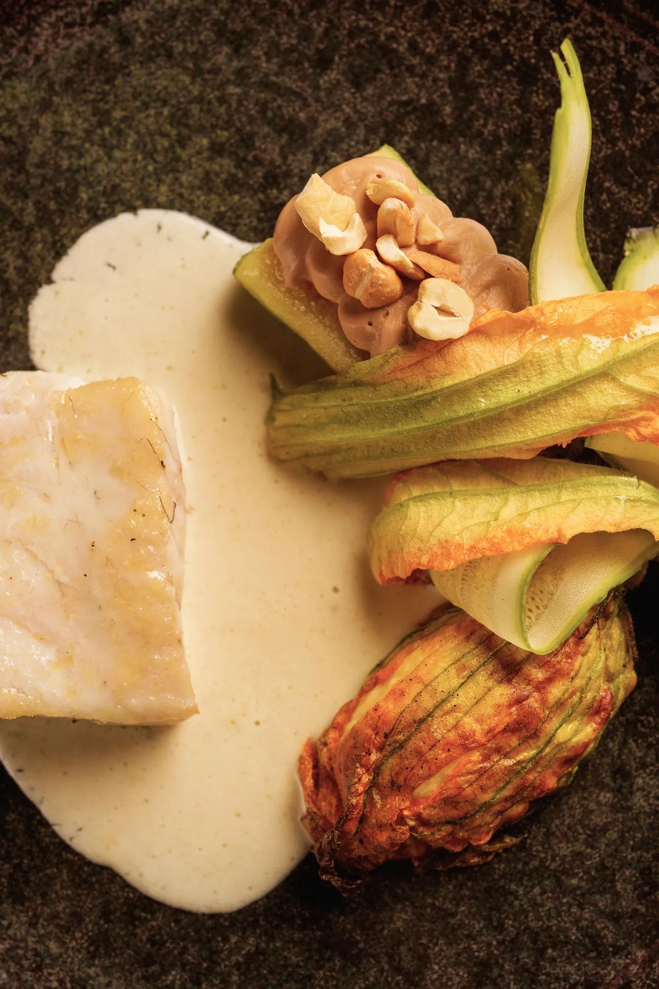 Person reading the Blaise menu at a dimly lit table at Rosewood São Paulo.