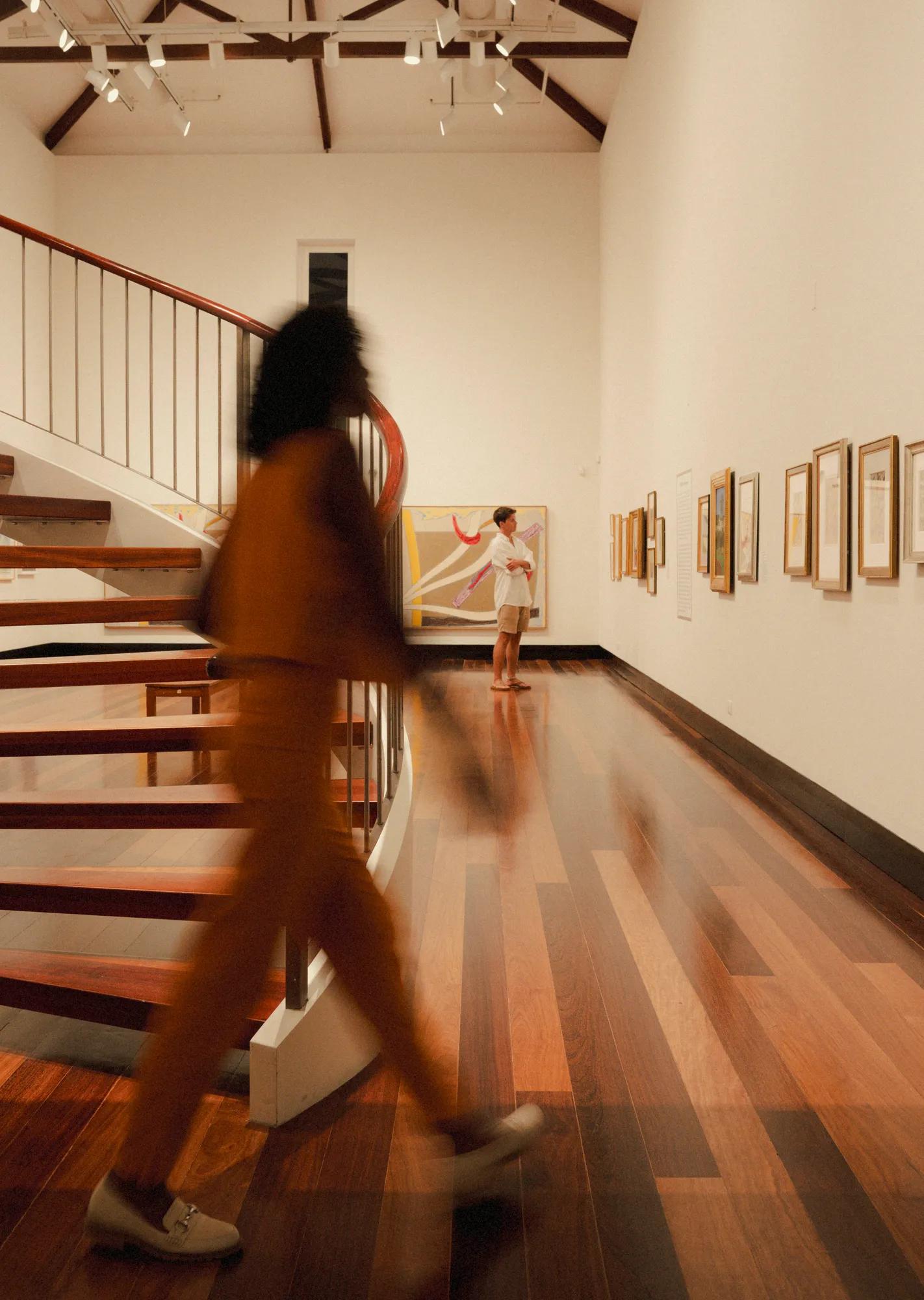 Person walking by the stairs at Masterworks Museum