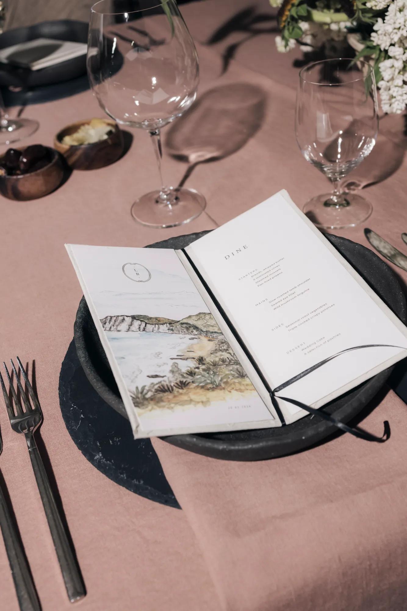 Close-up of a luxury wedding menu featuring an illustration of the Cape Kidnappers Peninsula alongside the menu details.