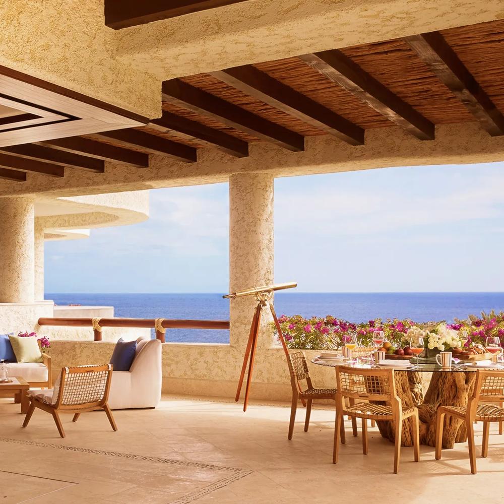Expansive private terrace with infinity pool and jacuzzi, outdoor living room and dining table overlooking the ocean.
